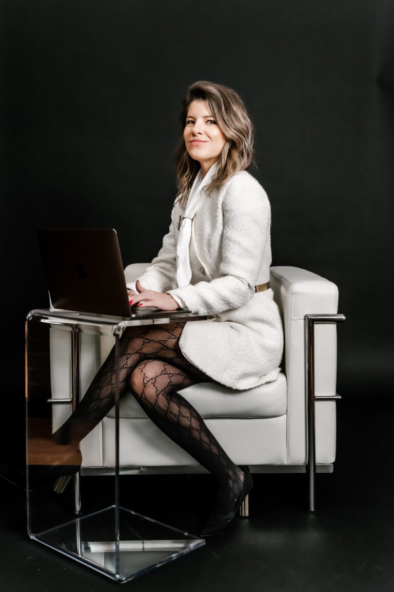 Tiffany Elking Illinois lawyer and lobbyist on her computer in a white dress and Gucci tights